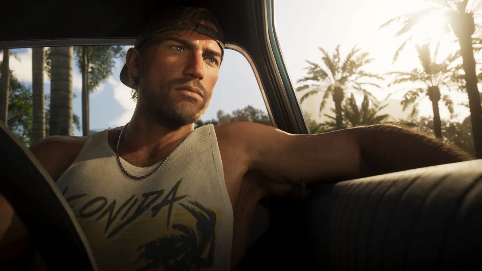 Jason de GTA 6 conduisant un cabriolet sur une route de Vice City bordée de palmiers en plein jour.